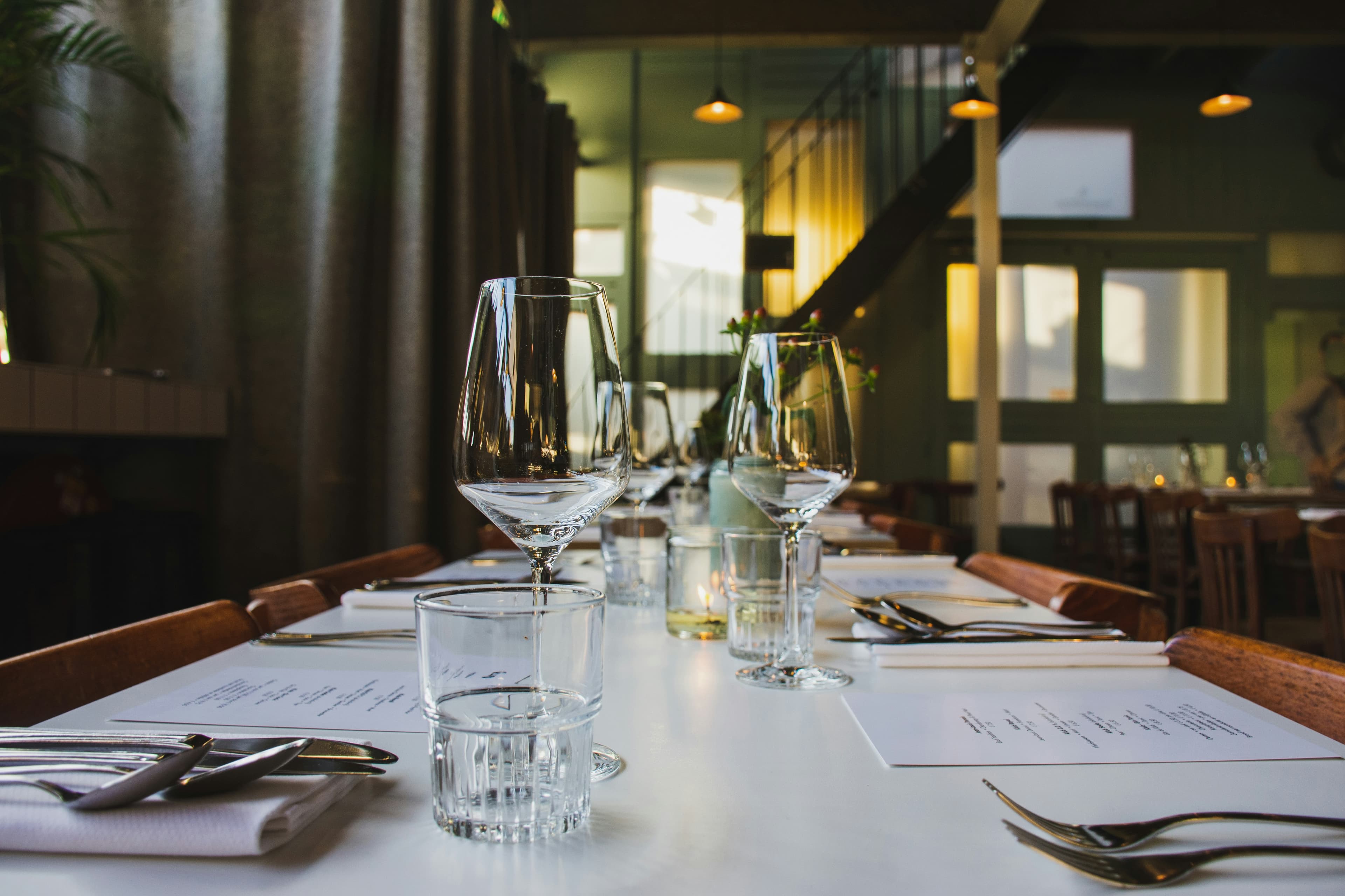 Candlelit restaurant table set with wine glasses — the kind of evening dining the Dunsborough strip does well