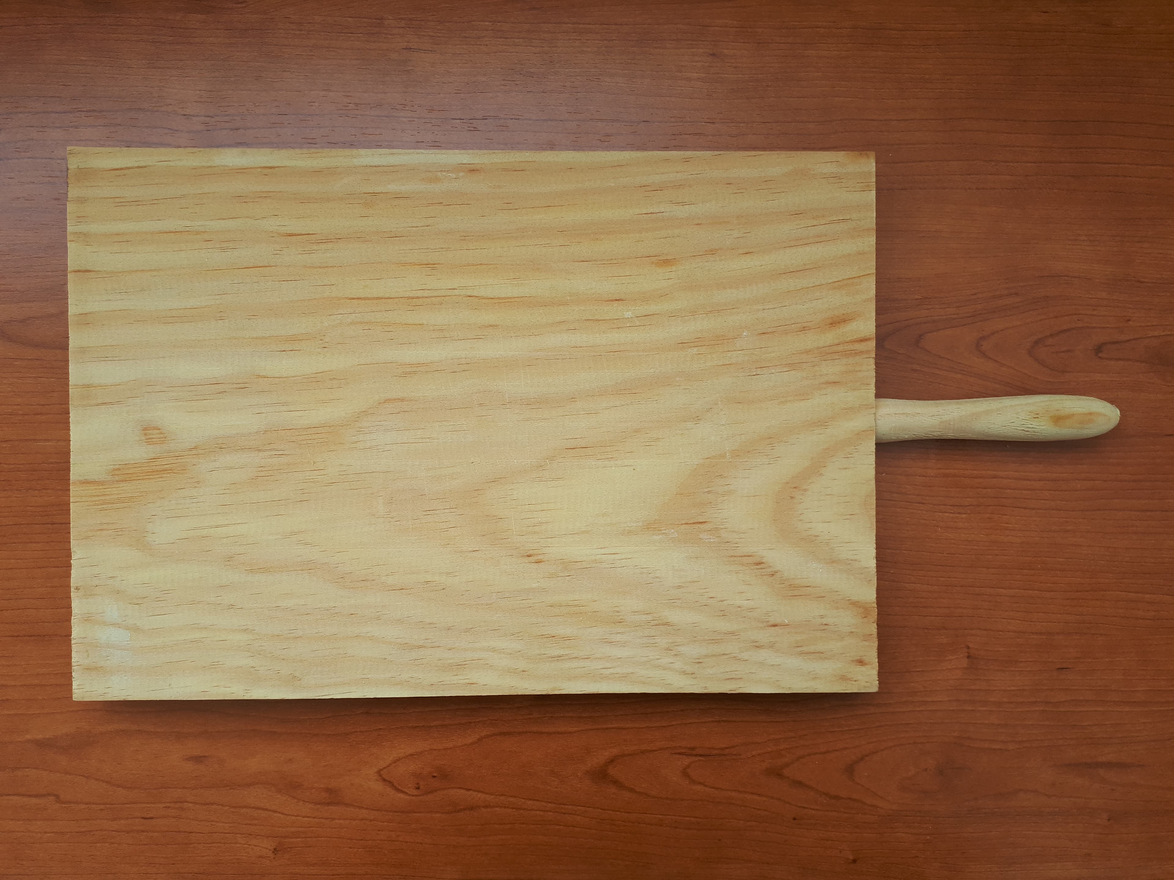 Handcrafted wooden cutting/serving board on a timber surface