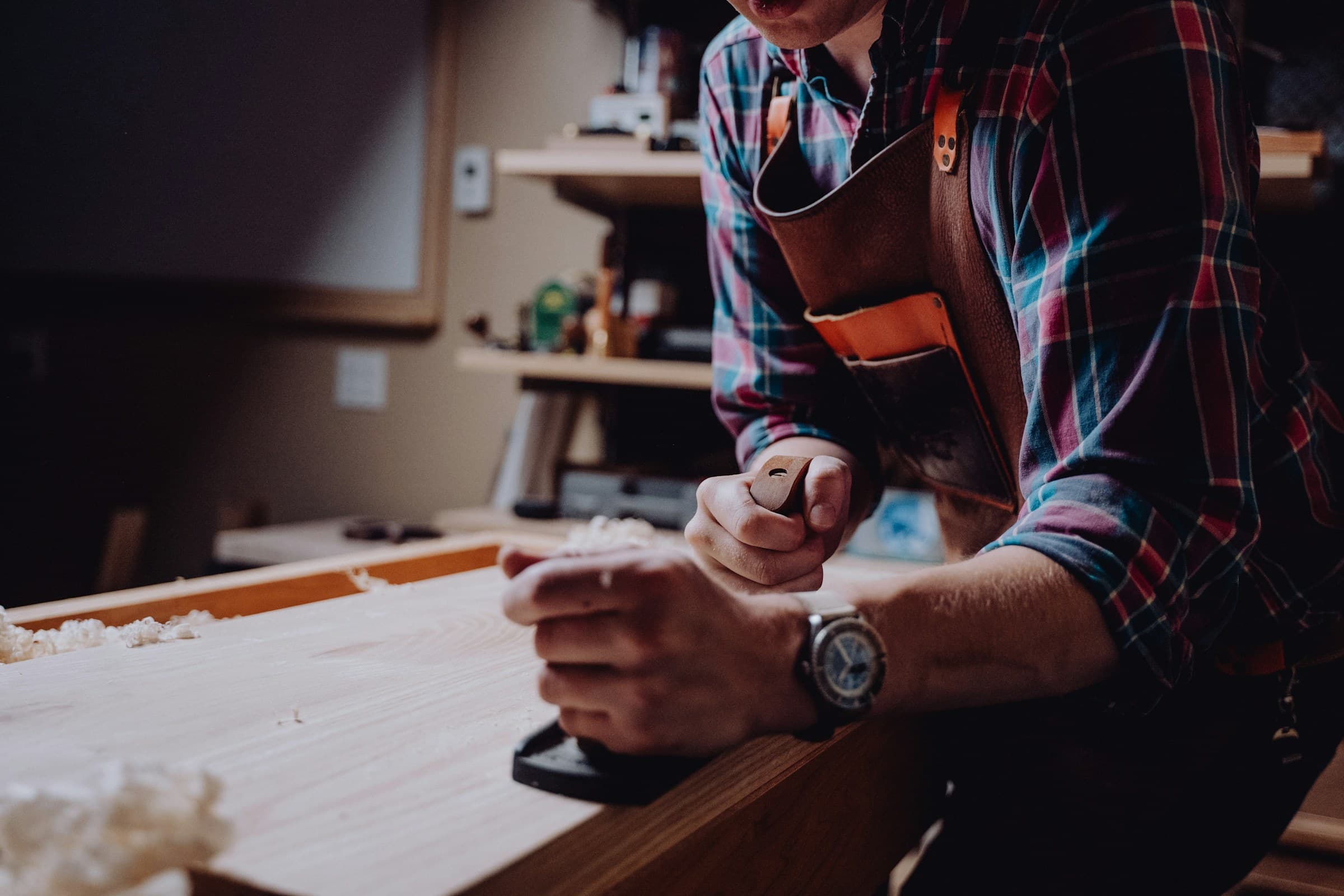 Woodworker shaping a piece of timber in a workshop