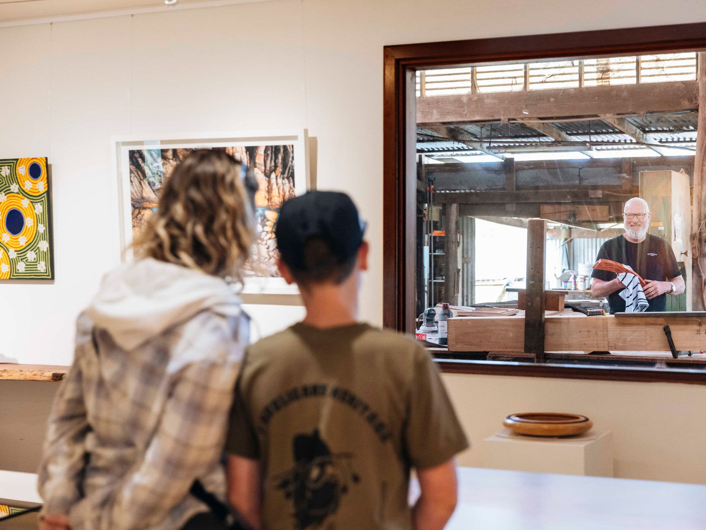 Visitors watching John Streater at work through the workshop window