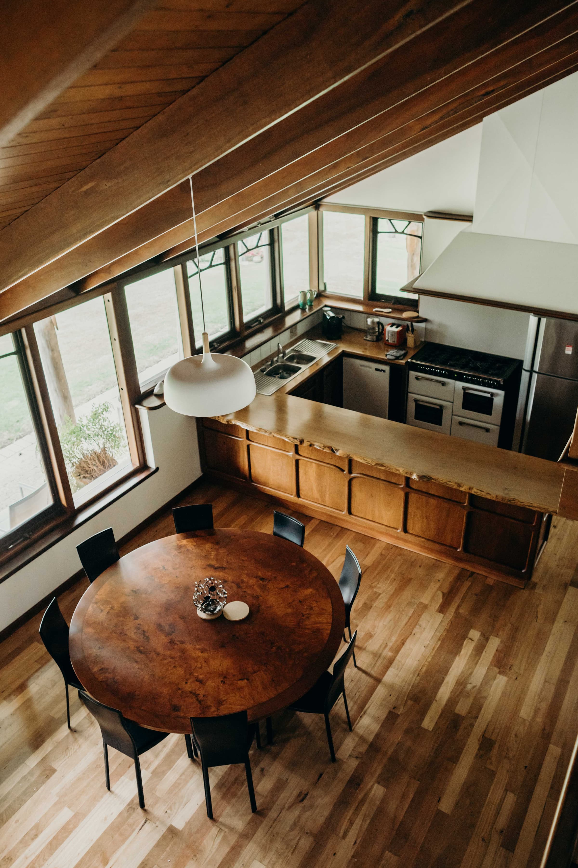 A round jarrah dining table in an open-plan home, seen from above